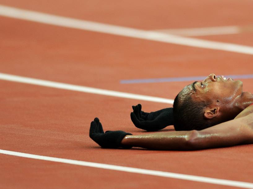 O atleta Agus Prayogo da Indonésia cai na pista depois de terminar em segundo lugar a final masculina dos 5000m