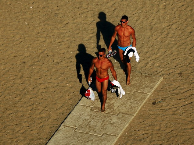 Banhistas caminham sob o sol na praia de La Malagueta, em Málaga, sul da Espanha - 27/06/2015