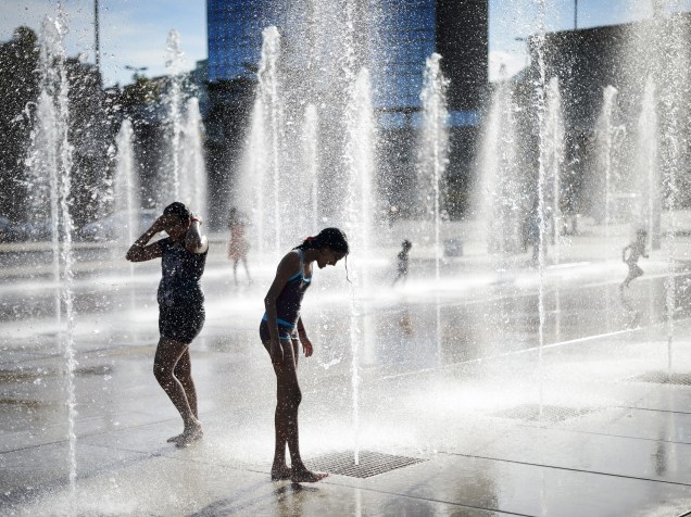 Meninas brincam no meio das fontes na Place des Nations, em Genebra, na Suíça - 29/06/2015
