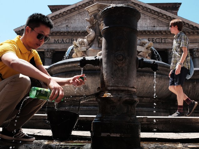 Homem enche sua garrafa com água em uma fonte pública Roma, na Itália. As temperaturas ultrapassaram os 40 graus Celsius na Europa Ocidental - 01/07/2015