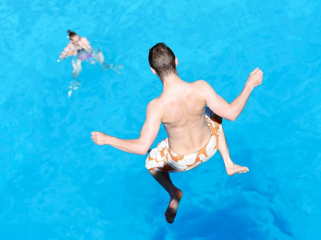 Homem salta em uma piscina durante um dia quente de verão em Hamburgo, norte da Alemanha - 02/07/2015
