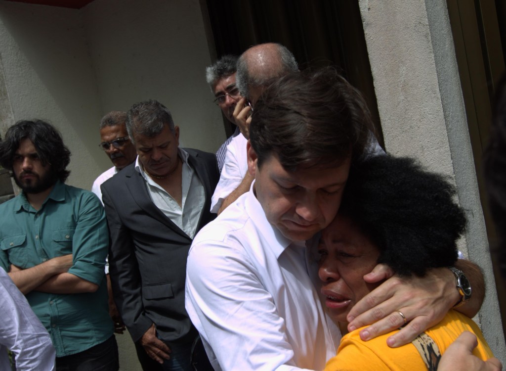 Geraldo Julio consola mulher em frente à casa de Eduardo Campos