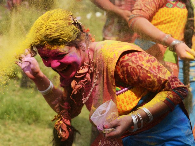 Foliões se divertem com pó colorido durante celebrações do festival Holi, em Siliguri, na Índia