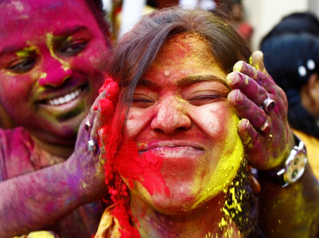 Foliões se divertem com pó colorido durante celebrações do festival Holi, em Calcultá, na Índia