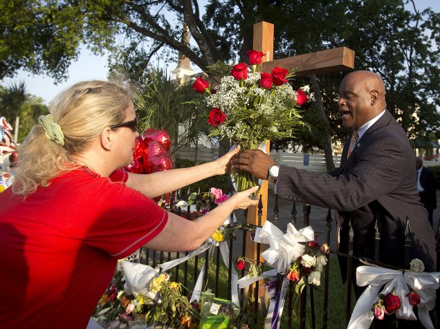 Fiéis depositam flores em frente à igreja de Charleston, invadida por jovem branco que atirou e matou 9 negros que estudavam a Bíblia