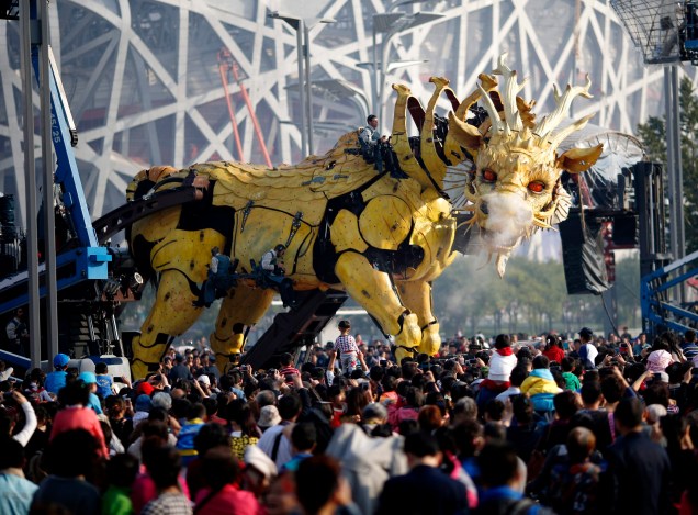 O robô Long Ma, de 15 metros de altura, comandado por vários operadores, emitir vapor durante apresentação em frente ao Estádio Nacional, conhecido como Ninho do Pássaro, em Pequim, China, nesta sexta-feira (17)