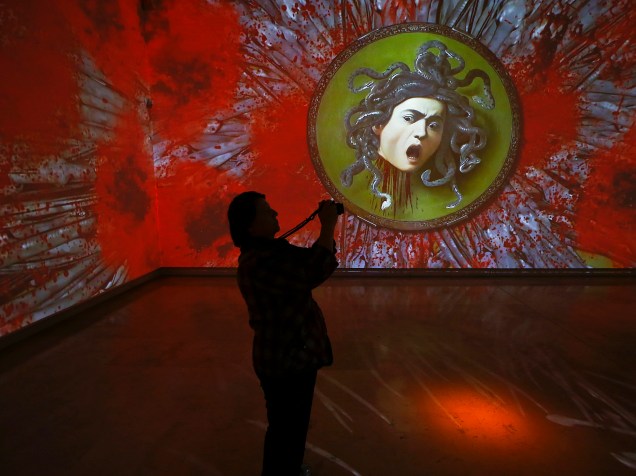 Visitante fotografa uma instalação intitulada "Caravaggio Experience" realizada pelo designer de vídeos Stefano Fake em exibição no Palazzo delle Esposizioni, em Roma, na Itália - 04/04/2016