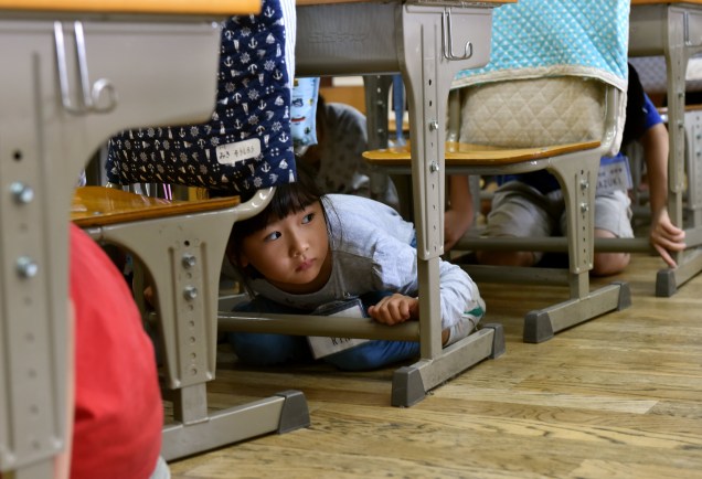 Crianças em sala de aula participam do exercício de simulação contra terremoto em Tóquio, no Japão