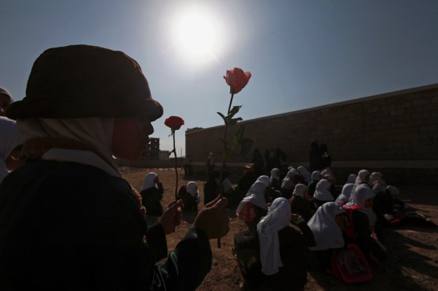 Em frente à escola que foi tomada por rebeldes Xiitas em Sanaa, Yemen, estudante carrega flor simbolizando seu não envolvimento com a guerra 