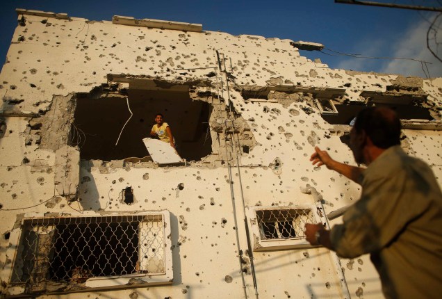 Palestino remove seus pertences de sua casa que foi detonada, segundo testemunhas, durante a ofensiva contra Gaza