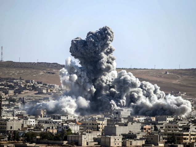 Coluna de fumaça é vista após explosão na cidade de Kobane, também conhecido como Ain al-Arab, na Síria. O governo americano, aliado a várias potências mundiais, tem realizado uma série de ataques aéreos em um tentativa de combater o avanço de militantes do Estado Islâmico (EI) por todo o território