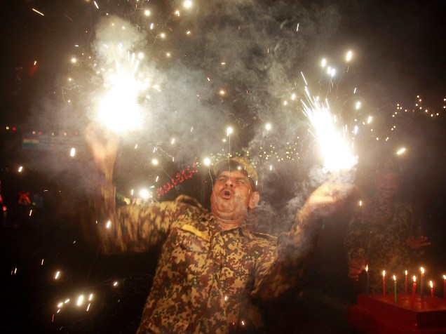 Soldado da Força de Segurança de Fronteiras (BSF) solta fogos as vésperas do Festival Diwali, nos arredores de Agartala, na Índia