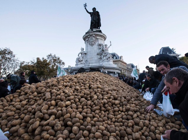 Agricultores colocaram batatas em sacos antes da distribuição na Praça Republique, no centro de Paris. Sindicatos dos agricultores franceses organizaram um dia nacional de protesto contra as restrições e encargos crescentes e a queda dos preços de cereais, leite e vegetais, causada em parte pelas sanções sobre a Rússia - 05/11/2014