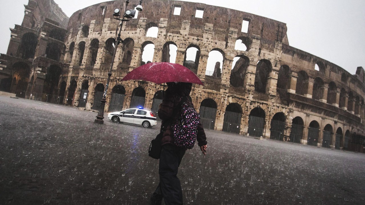 Mulher caminha sob forte chuva nos arredores do Coliseu, em Roma. As fortes chuvas que atingem a capital italiana provocaram o fechamento de escolas - 06/11/2014