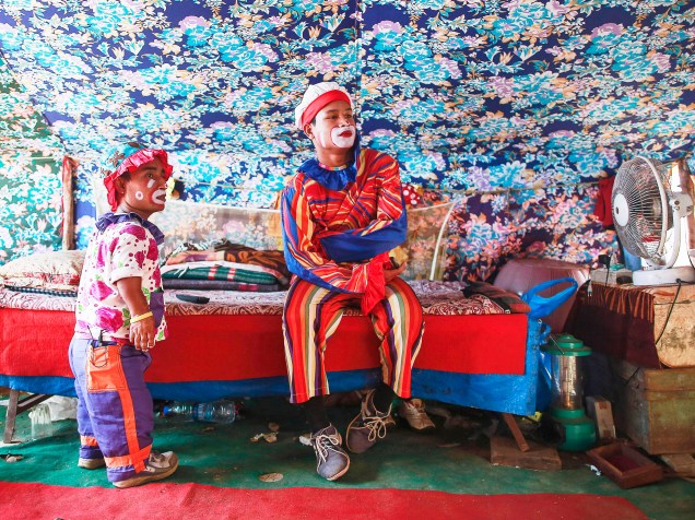 Palhaços assistem televisão dentro de sua barraca antes de um show no Rambo Circus em Mumbai, na Índia - 06/11/2014
