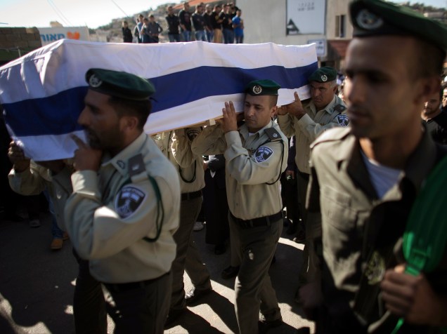 Oficiais israelenses da Polícia de Fronteiras carregaram um caixão coberto com a bandeira nacional, durante funeral de um guarda, na região da Galiléia, em Israel