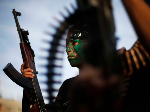 Garoto palestino do exército popular do Hamas segura sua arma durante a cerimônia de graduação militar, no campo de refúgio de Jabaliy, na Faixa de Gaza