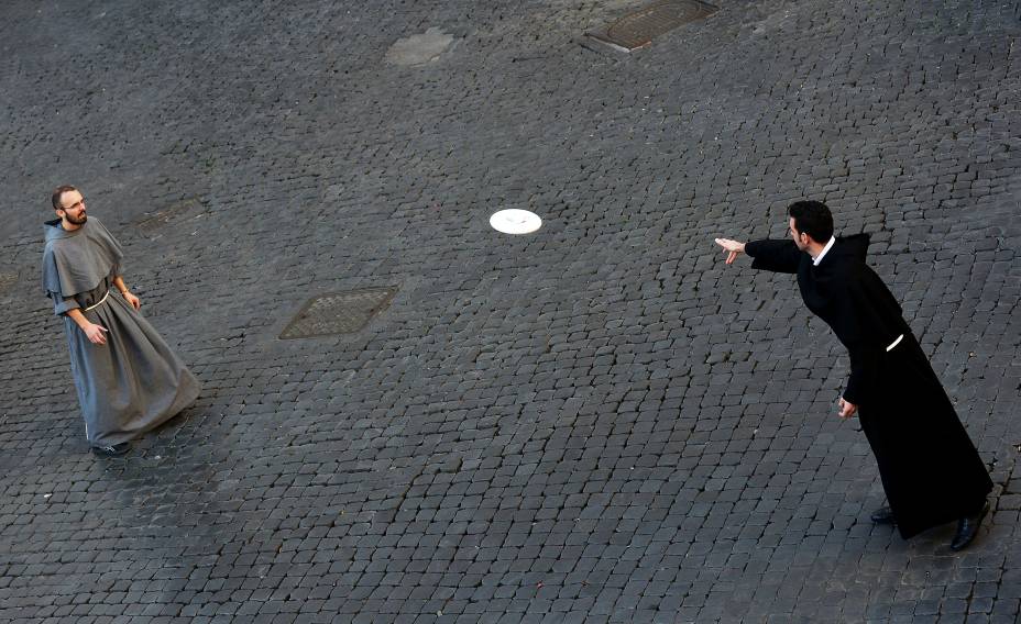 Frades jogam discos, na Praça Santo Apóstolo, em Roma, Itália 