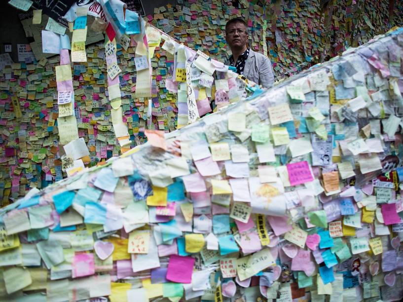 Homem passa por um muro repleto de mensagens deixadas por manifestantes pró-democracia que realizam, desde setembro, um movimento de ocupação em Hong Kong contra a intervenção da China na escolha dos governantes locais - 10/11/2014