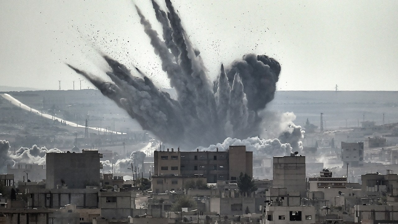 Muita fumaça é vista sobre a cidade síria de Kobane. Relatório divulgado hoje (13) pelo Conselho Norueguês de Refugiados junto ao Comitê Internacional de Resgate diz que os sírios estão cada vez mais incapazes de escapar da guerra em seu próprio país, causando a emigração de milhares de pessoas