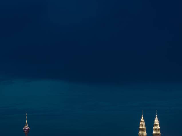 Na imagem, pontas das Torres Petronas são vistas iluminadas com luzes ao anoitecer, na cidade de Kuala Lumpur, capital da Malásia