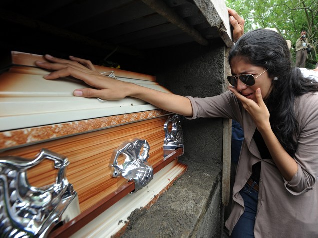 Mulher chora ao lado do caixão da ex-Miss Honduras, Maria José Alvarado, assassinada junto com a irmã Sofia Trinidad Alvarado, na cidade de Santa Bárbara