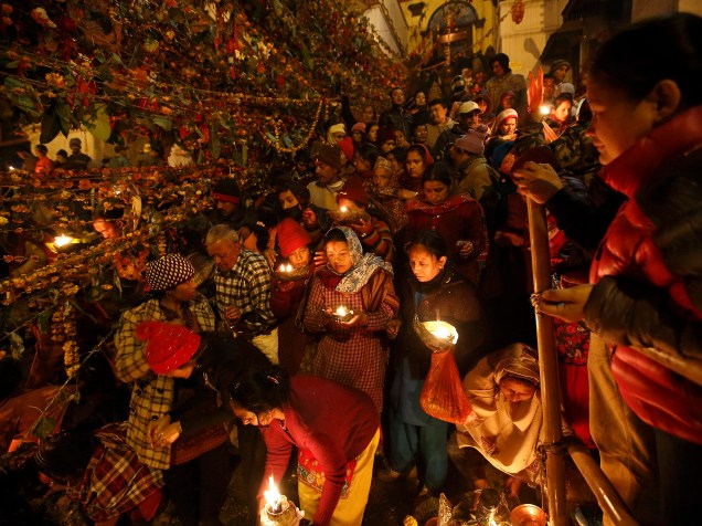 Devotos hindus com lâmpadas de óleo durante ritual nas instalações do templo de Pashupatinath, para celebrar o Festival Bala Chaturdashi, em Katmandu, no Nepal
