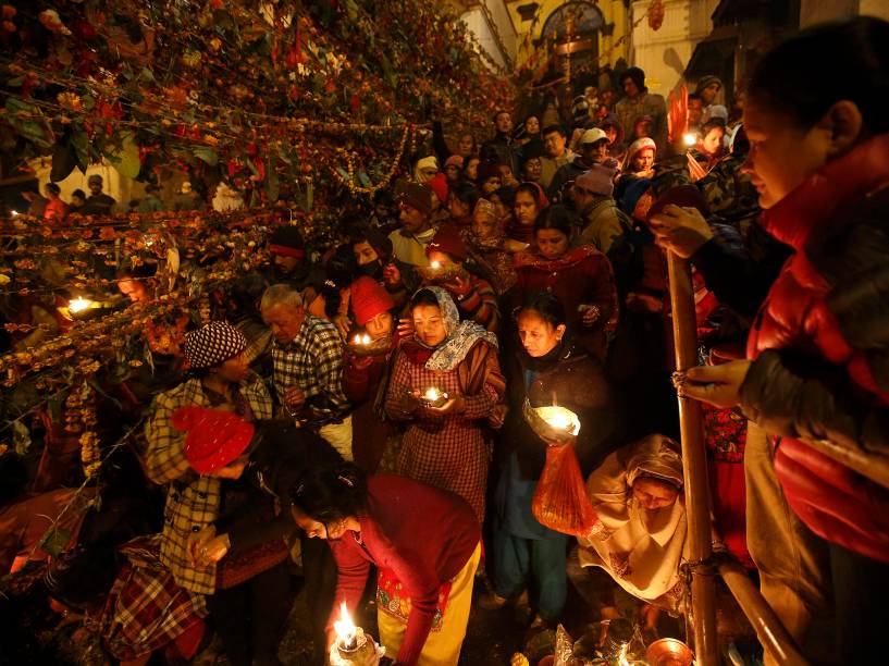 Devotos hindus seguram lâmpadas de óleo durante ritual nas instalações do templo de Pashupatinath, para celebrar o Festival Bala Chaturdashi, em Katmandu, no Nepal