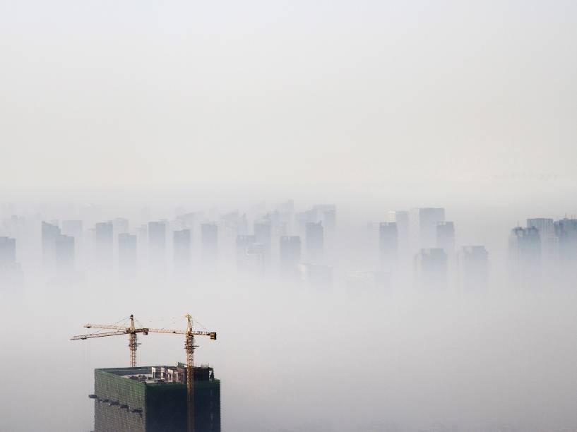 Edifício em construção é visto em meio a uma densa nuvem de poluição em Shenyang, província de Liaoning, na China - 21/11/2014