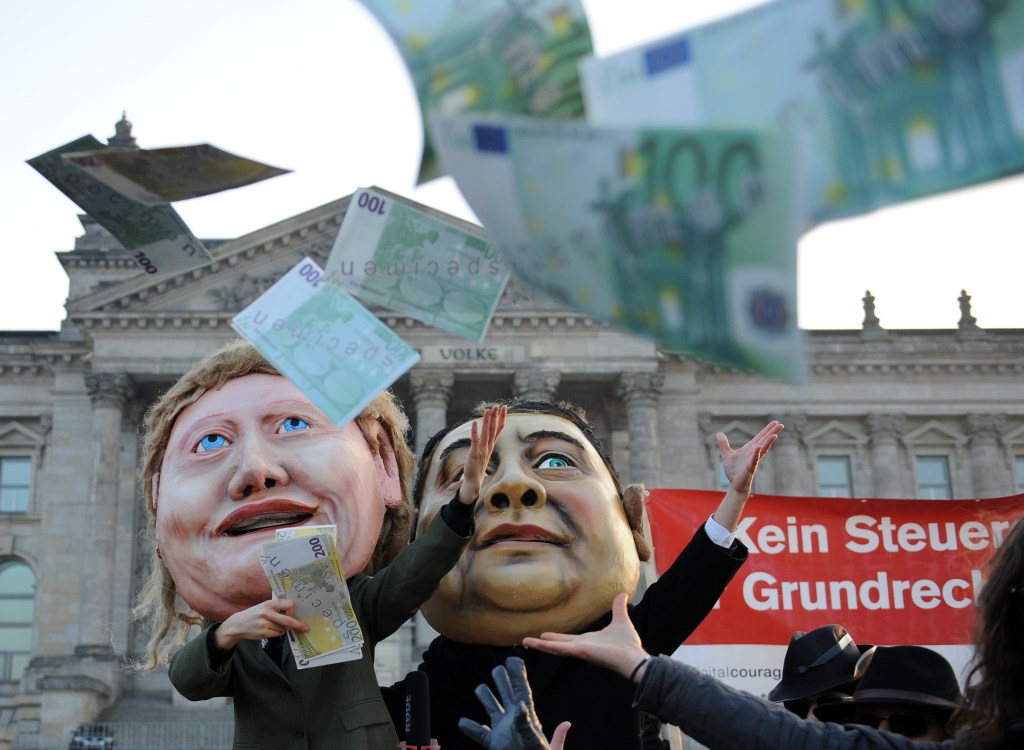 Em Berlim, ativistas jogam notas falsas de euro em protesto contra os planos de aumento no orçamento do serviço de inteligência alemão