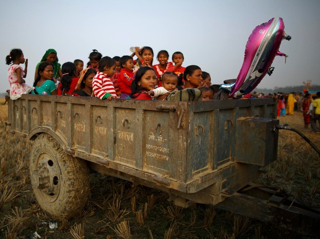 Familiares e amigos se acomodam em um reboque de veículos, onde passarão a noite, na véspera da cerimônia de sacrifício para o festival Gadhimai Mela, em Bariyapur, no Nepal 