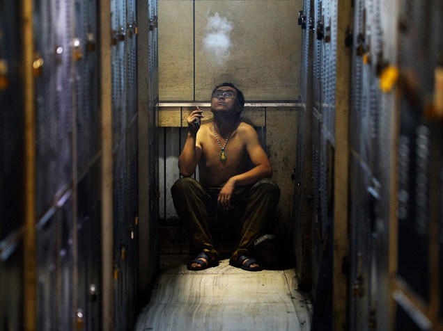Homem fuma um cigarro ao lado durante uma pausa no trabalho em uma mina de carvão, na província de Shanxi, na China