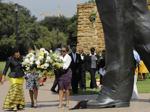 A viúva de Nelson Mandela, Graça Machel (e), deposita flores em monumento no primeiro ano da morte do líder sul-africano