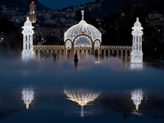Turistas tiram fotos em frente a instalação de luzes de Natal em Nice, sudeste da França