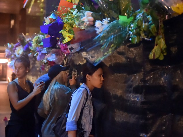 Mulheres deixam flores em homenagem aos reféns mortos durante um sequestro a uma cafeteria em Sydney, na Austrália. Depois de quase 17 horas, dois reféns, além do sequestrador, terminaram mortos