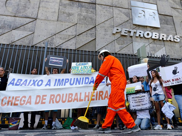 Um manifestante limpa a entrada principal da sede da Petrobras, no Rio de Janeiro, durante um protesto contra a corrupção 