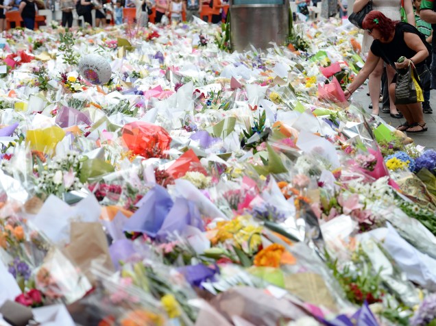 Australianos depositam flores em memorial improvisado em homenagem às vítimas do sequestro em cafeteria de Sydney nesta quinta-feira (18/12). Três pessoas foram mortas, incluindo o sequestrador