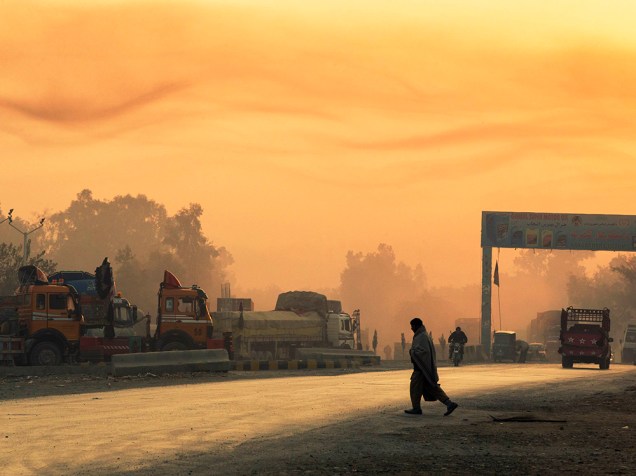 Homem atravessa a rua enquanto o dia amanhece nos arredores da Base Operacional de Fronte Fenty na província de Nangarhar, no Afeganistão 19/12/2014