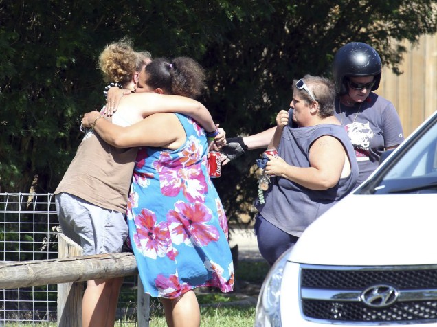 Mulheres choram em frente à casa onde foram encontradas oito crianças mortas a facadas na cidade de Cairns, no Estado de Queensland, na Austrália