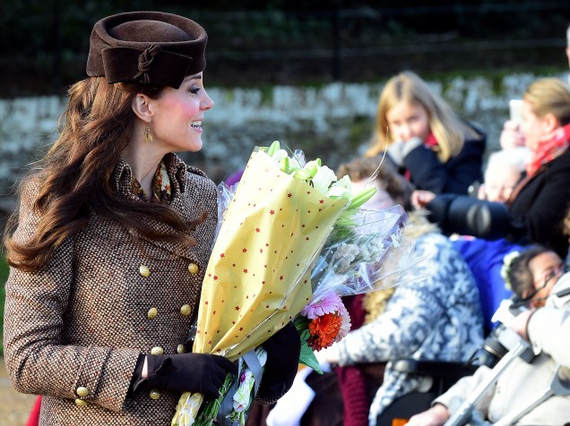   A duquesa de Cambridge, Kate Middleton, recebe nesta quinta-feira (25) flores de britânicos após participar com os outros membros da família real de um tradicional evento de Natal na igreja em Sandringham, ao leste da Inglaterra
