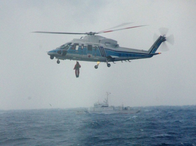 Imagem cedida pela Guarda Costeira do Japão mostra um helicóptero resgatando sobreviventes de um naufrágio no estreito que separa a ilha de Honshu do arquipélago de Hokkaido. Três dos 10 tripulantes morreram