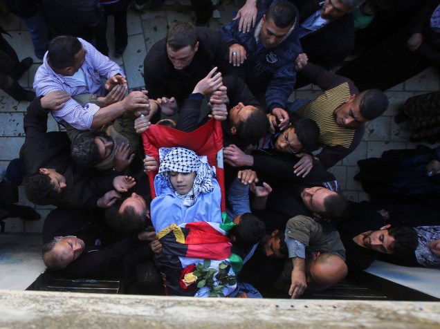 Homens carregam o corpo do palestino Imam Dwikat de 17 anos, morto a tiros por tropas israelenses, durante seu funeral na aldeia de Beita, na Cisjordânia. O jovem foi morto enquanto arremessava pedras em carros em uma rodovia ocupada na Cisjordânia - 30/12/2014