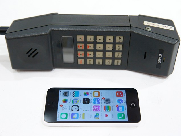 Uma foto-ilustração mostra um iPhone 5 ao lado de um telefone móvel na loja da Vodafone, em Oxford, durante um evento para marcar o 30º aniversário da primeira chamada de telefone móvel no Reino Unido