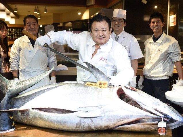 Kiyoshi Kimura (c), presidente da Kiyomura Co., proprietária da cadeia de restaurantes Sushi Zanmai, prepara-se para cortar um atum vermelho de 180 quilos após a compra por 4,51 milhões de ienes no primeiro leilão tradicional do ano no mercado de peixesTsukiji mercado em Tóquio - 05/01/2015