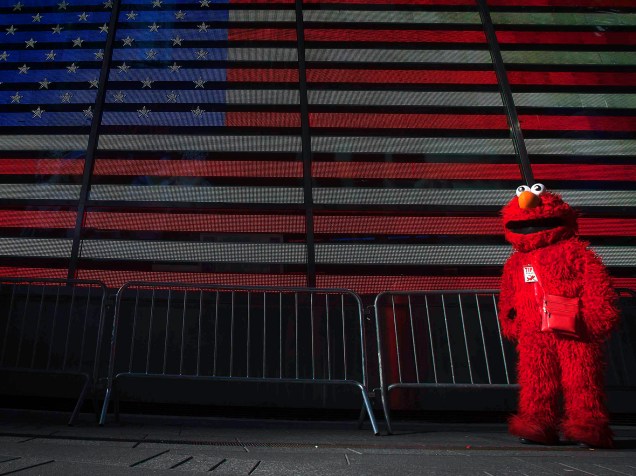 Personagem Elmo é visto em frente à bandeira norte-americana na Times Square, em Manhattan, Nova York