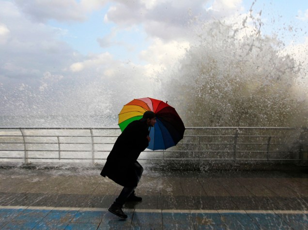 Homem se protegeu com um guarda chuva de uma onda em Corniche, em Beirute, no Líbano, durante um passeio à beira-mar antes de uma tempestade