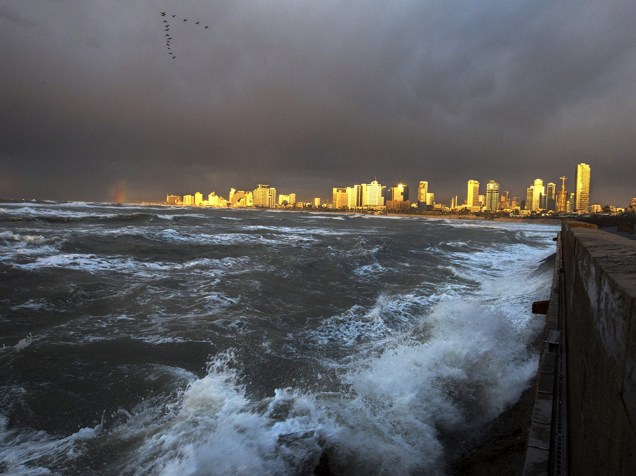 Sol ilumina os edifícios em Tel Aviv, capital de Israel, durante uma tempestade nesta quinta-feira (08)