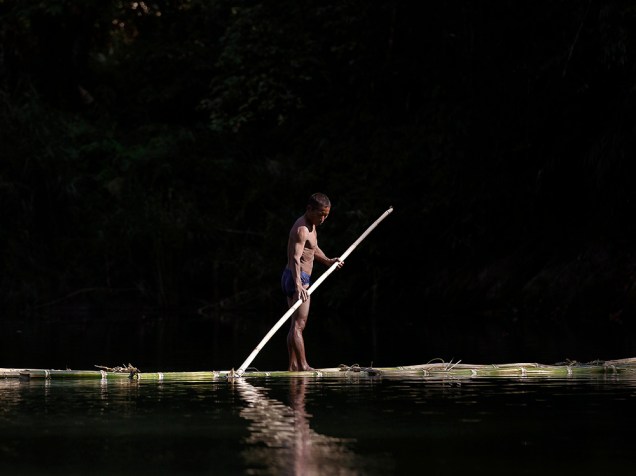 Homem é visto em jangada feita de bambu, em um riacho entre Donhe e Lahe, região noroeste do Mianmar