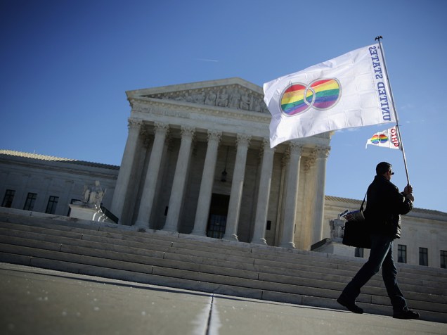 Homem carrega bandeira simbolizando a Igualdade de Gênero, do lado de fora do prédio da Suprema Corte dos Estados Unidos, em Washington