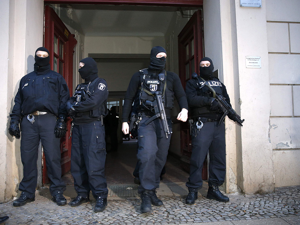 Unidades especiais da polícia alemã fazem guarda na entrada de um prédio no distrito de Wedding, em Berlim, na Alemanha. Cerca de 250 policiais participaram nesta sexta-feira (16) de uma operação que prendeu dois suspeitos de atividade terrorista